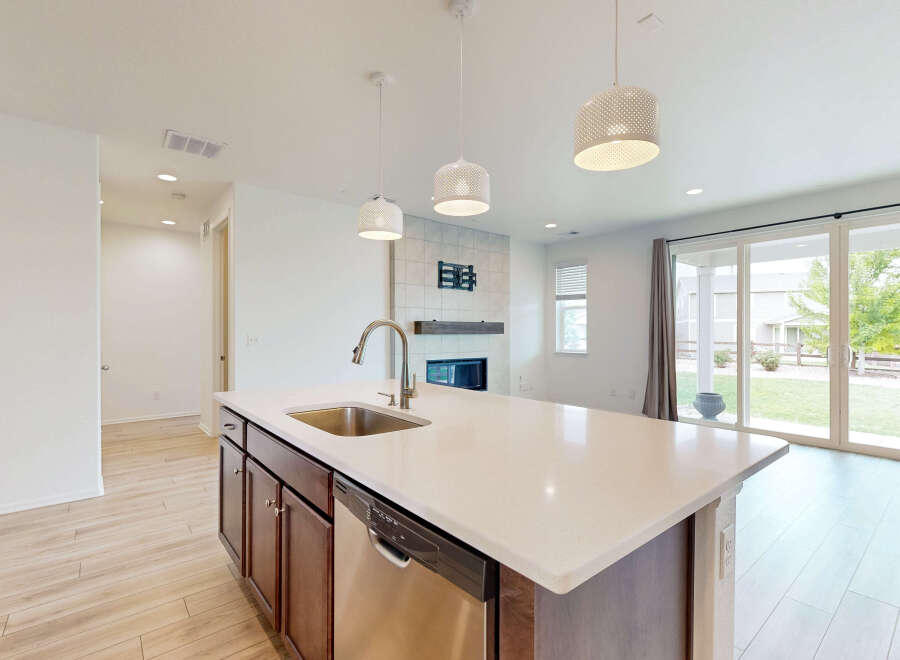 Experience modern living in this stunning open-concept home, featuring a sleek kitchen island with a built-in sink and dishwasher.