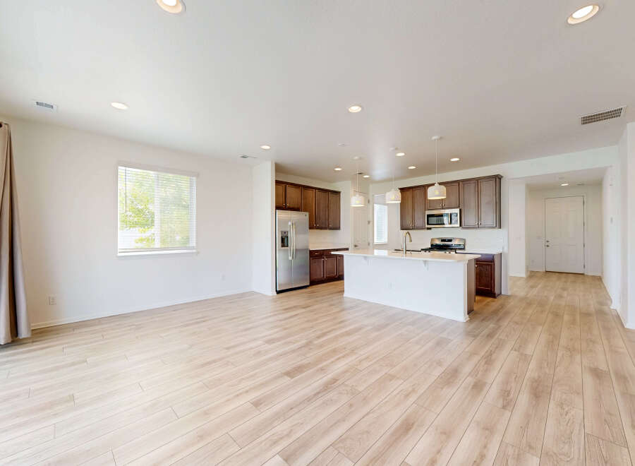 Experience modern living in this spacious open-concept home, featuring a sleek kitchen with a large island and ample cabinet space.