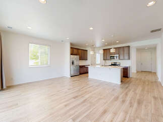 Experience modern living in this spacious open-concept home, featuring a sleek kitchen with a large island and ample cabinet space.