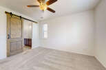 Step into this inviting bedroom featuring a stylish barn door that opens to an ensuite bathroom.