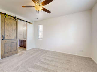 Step into this inviting bedroom featuring a stylish barn door that opens to an ensuite bathroom.