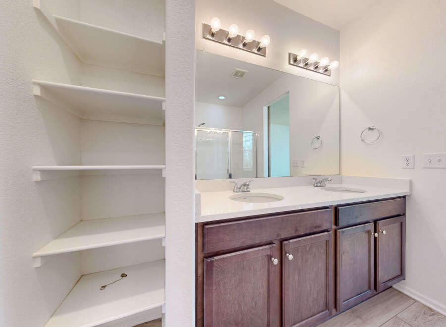 This spacious bathroom features a double vanity with two sinks and ample counter space, perfect for busy mornings.