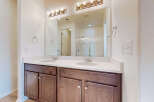 This modern bathroom features a spacious double vanity with a white quartz countertop and dark wood cabinetry.