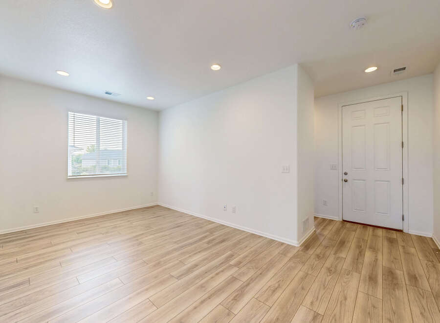 Step into this bright and airy living space featuring a large window that floods the room with natural light.