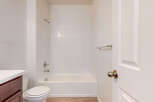 This bathroom features a pristine white tiled shower and tub combination, perfect for relaxing soaks.