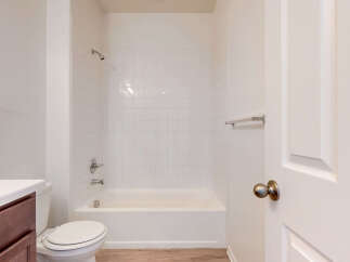 This bathroom features a pristine white tiled shower and tub combination, perfect for relaxing soaks.