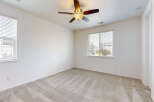 This spacious bedroom features plush carpeting and a ceiling fan for comfort.