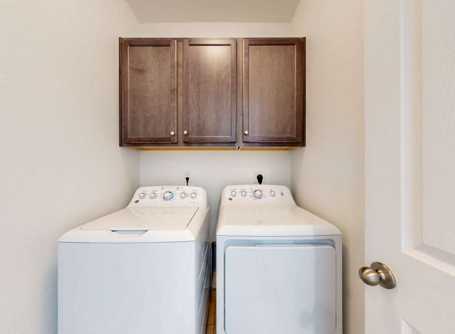 This laundry room features a stacked GE washer and dryer set, perfect for maximizing space.
