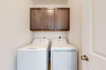 This laundry room features a stacked GE washer and dryer set, perfect for maximizing space.
