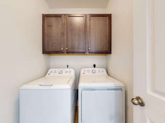 This laundry room features a stacked GE washer and dryer set, perfect for maximizing space.