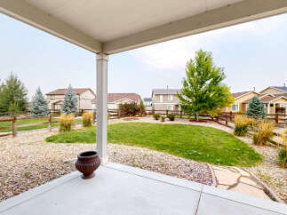 Enjoy outdoor living from this covered patio overlooking a spacious backyard.