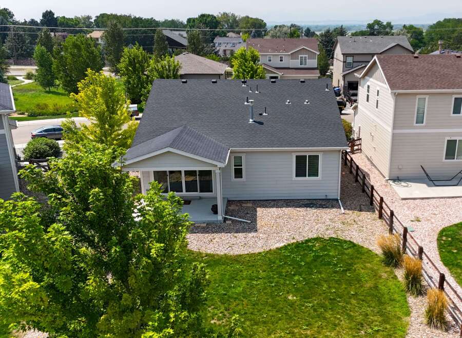 Discover this charming home featuring a spacious backyard with lush green grass and a gravel patio, perfect for outdoor entertaining.