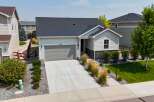 Discover this charming single-family home featuring a modern gray garage door and a welcoming entryway with stone accents.