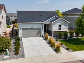 Discover this charming single-family home featuring a modern gray garage door and a welcoming entryway with stone accents.
