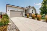 This charming single-family home features a spacious concrete driveway leading to a two-car garage, perfect for vehicle storage and workspace.