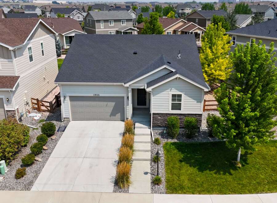 Discover this charming single-family home featuring a modern gray garage door and a welcoming light gray exterior.