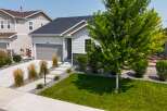 Discover this charming single-family home featuring a modern exterior with light gray siding and stone accents.