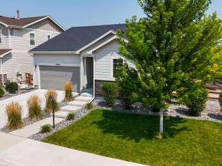 Discover this charming single-family home featuring a modern exterior with light gray siding and stone accents.