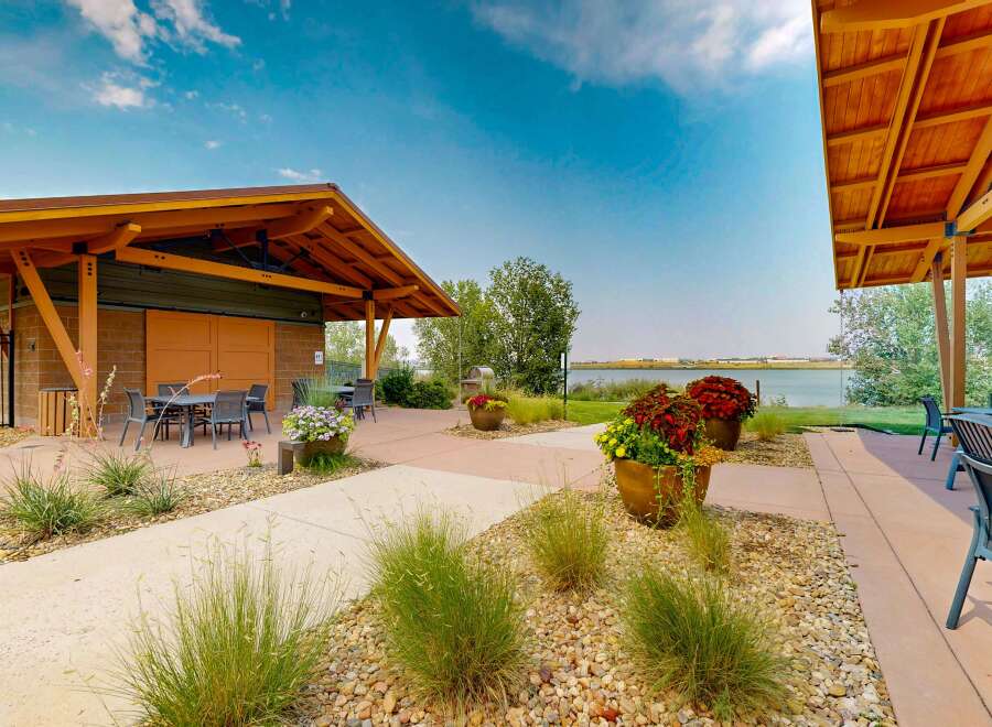 Enjoy outdoor living with this covered patio featuring comfortable seating and a dining area, perfect for entertaining guests.