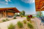 Enjoy outdoor living with this covered patio featuring comfortable seating and a dining area, perfect for entertaining guests.