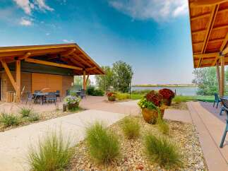 Enjoy outdoor living with this covered patio featuring comfortable seating and a dining area, perfect for entertaining guests.