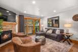 Cozy up by the fireplace in this inviting living room, featuring plush seating and a large sectional perfect for relaxing.