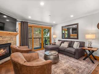 Cozy up by the fireplace in this inviting living room, featuring plush seating and a large sectional perfect for relaxing.