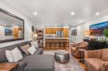 Experience modern living in this spacious open-concept living area, featuring a comfortable sectional sofa and stylish accent chairs perfect for relaxation.