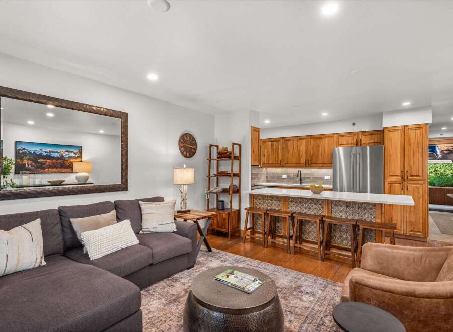 Experience modern living in this beautifully appointed open-concept space, featuring a sleek kitchen with ample cabinetry and a breakfast bar perfect for casual dining.