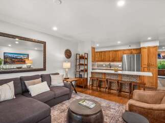 Experience modern living in this beautifully appointed open-concept space, featuring a sleek kitchen with ample cabinetry and a breakfast bar perfect for casual dining.