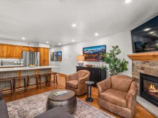 Experience modern living in this open-concept space, featuring a gourmet kitchen with rich wood cabinetry and a sleek island perfect for entertaining.