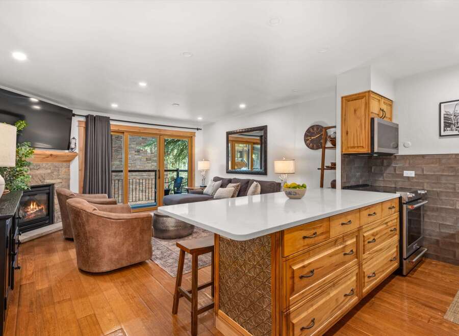 Experience modern living in this beautifully appointed open-concept space, featuring a cozy fireplace and a large flat-screen TV for ultimate relaxation.