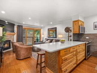 Experience modern living in this beautifully appointed open-concept space, featuring a cozy fireplace and a large flat-screen TV for ultimate relaxation.