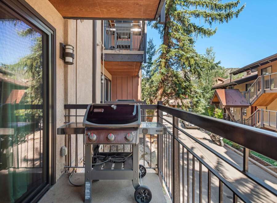 Enjoy outdoor living on this charming balcony, complete with a Weber grill perfect for summer cookouts.