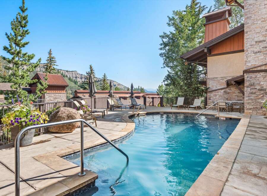 Enjoy a refreshing dip in this stunning outdoor pool, surrounded by lush greenery and breathtaking mountain views.