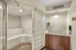 Experience ultimate relaxation in this luxurious steam room, featuring elegant white tiled walls and built-in seating for a spa-like experience.