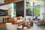 Experience modern mountain living in this stunning open-concept living space, featuring a plush burnt orange sofa and cozy boucle armchairs perfect for relaxation.