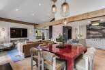 Experience modern luxury in this open-concept living space, featuring a striking red dining table as the centerpiece.