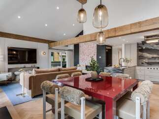Experience modern luxury in this open-concept living space, featuring a striking red dining table as the centerpiece.