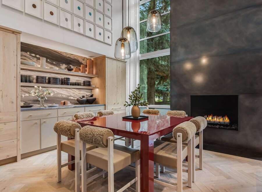Experience luxurious dining in this stunning space, featuring a vibrant red dining table and unique, plush-accented chairs.