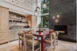 Experience luxurious dining in this stunning space, featuring a vibrant red dining table and unique, plush-accented chairs.