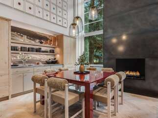 Experience luxurious dining in this stunning space, featuring a vibrant red dining table and unique, plush-accented chairs.
