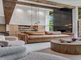Experience luxury living in this stunning modern home, featuring a spacious living area with a large sectional sofa and a striking metal fireplace.
