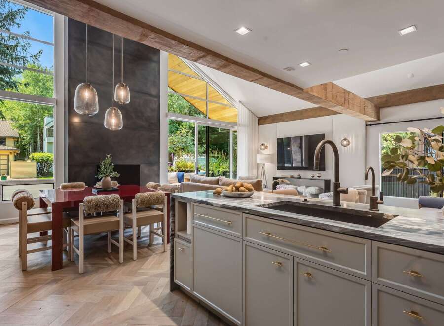 Experience modern luxury in this open-concept living space, featuring a stunning fireplace and expansive windows that flood the area with natural light.