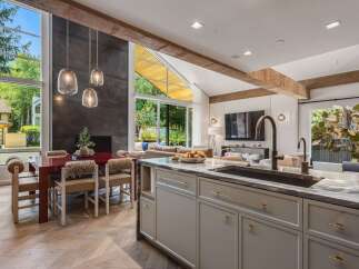 Experience modern luxury in this open-concept living space, featuring a stunning fireplace and expansive windows that flood the area with natural light.