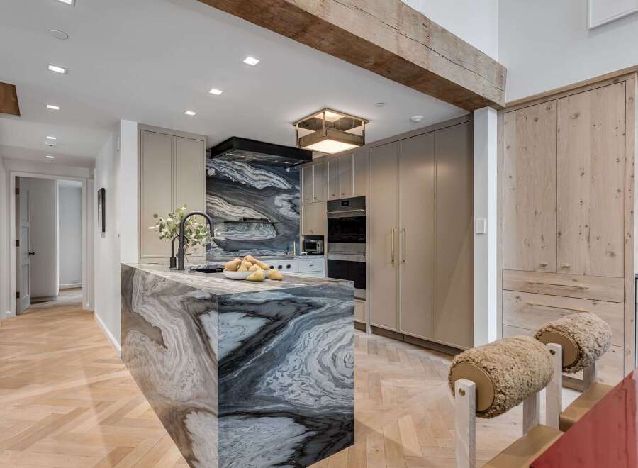 Experience luxury in this stunning kitchen featuring a dramatic marble island and backsplash.