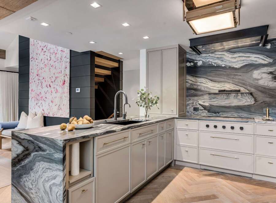 Experience luxury in this stunning modern kitchen, featuring a dramatic marble waterfall island and a captivating marble backsplash.