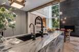 Experience luxury in this modern kitchen featuring a stunning marble island with a deep sink and sleek faucets.