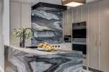 Experience luxury in this stunning kitchen, featuring a dramatic marble island and backsplash that command attention.