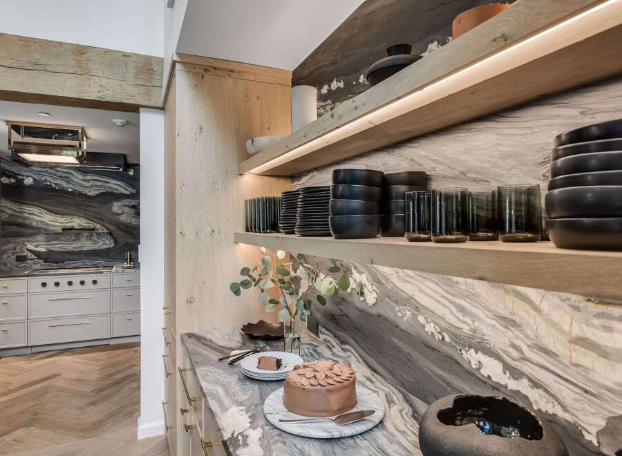 Experience luxury in this stunning kitchen, featuring a dramatic marble backsplash and sleek, modern cabinetry.